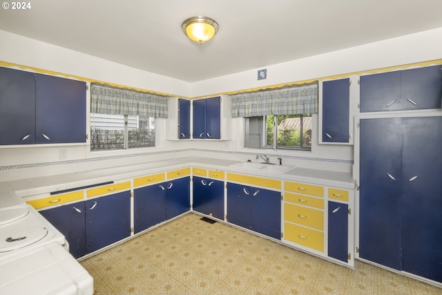 kitchen with blue cabinetry, sink, and a healthy amount of sunlight