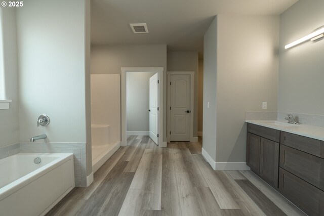 bathroom featuring hardwood / wood-style floors, vanity, and a bathing tub