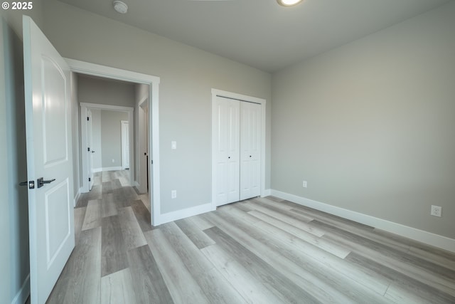 unfurnished bedroom featuring light hardwood / wood-style floors and a closet