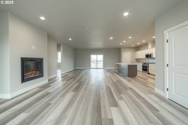 unfurnished living room featuring light hardwood / wood-style floors and sink