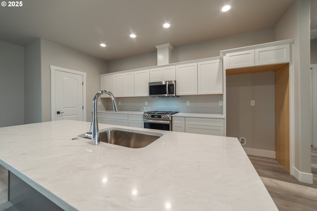 kitchen featuring white cabinets, stainless steel appliances, and sink