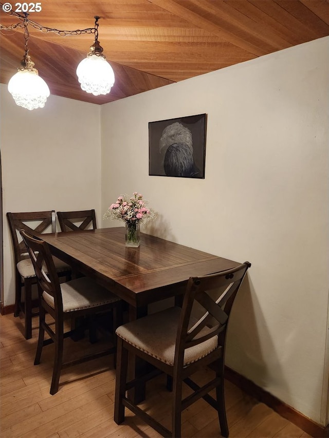 dining area with light hardwood / wood-style floors and wooden ceiling