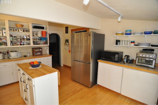 kitchen featuring white cabinetry, a center island, stainless steel fridge, and light hardwood / wood-style floors