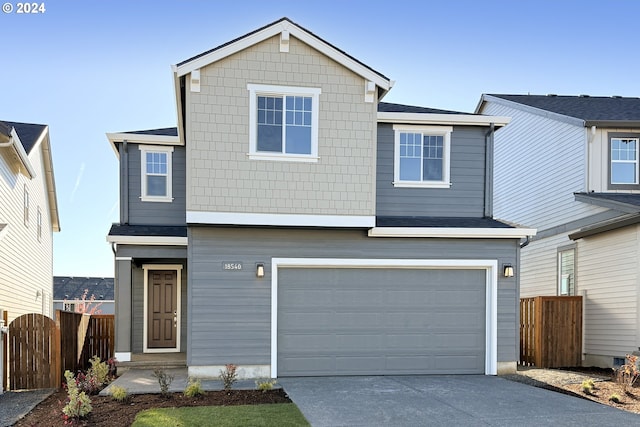 traditional-style home with a gate, driveway, an attached garage, and fence