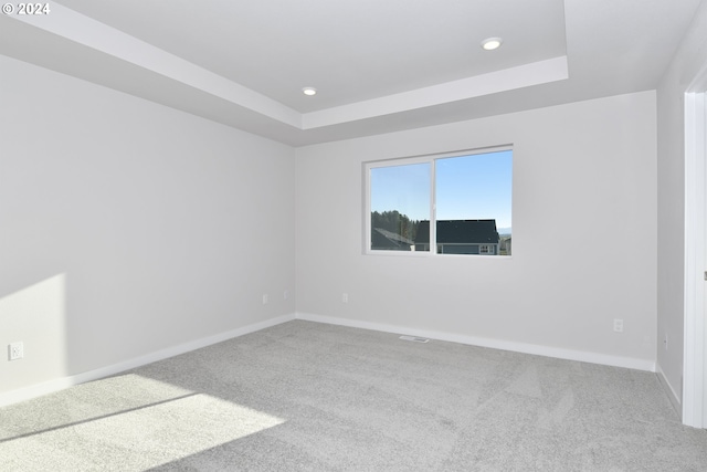 unfurnished room with a raised ceiling, recessed lighting, baseboards, and carpet floors