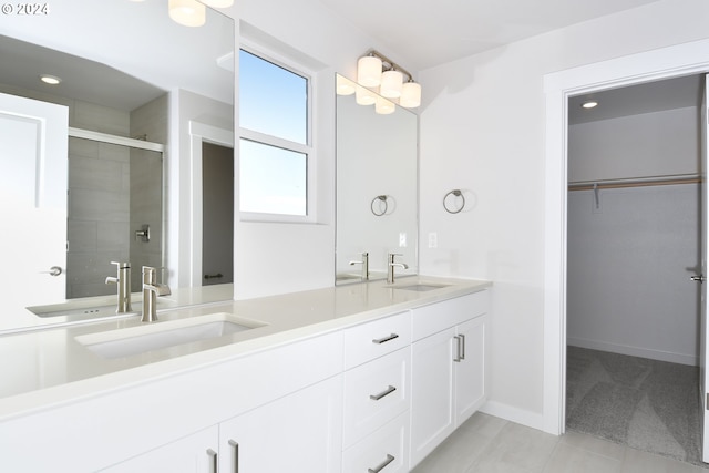 full bathroom featuring a stall shower, a walk in closet, and a sink