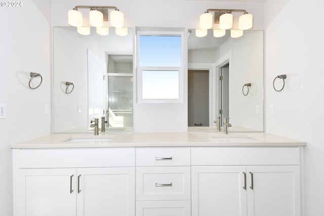 full bathroom with double vanity, a stall shower, and a sink