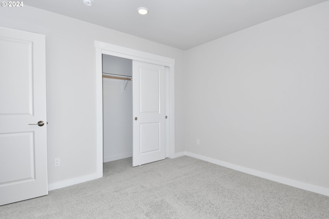 unfurnished bedroom with a closet, baseboards, and carpet