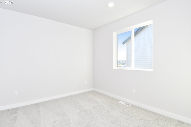 empty room featuring visible vents, baseboards, and carpet flooring