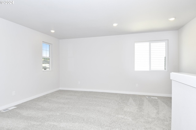 carpeted empty room featuring recessed lighting, baseboards, and visible vents