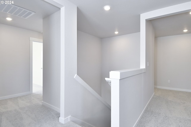 hallway featuring recessed lighting, visible vents, an upstairs landing, and carpet floors