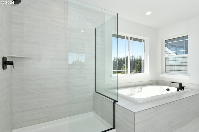 bathroom featuring independent shower and bath