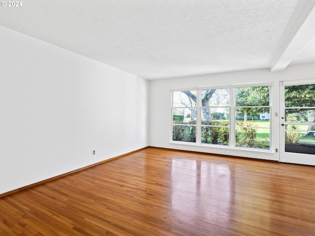 spare room with hardwood / wood-style floors and a textured ceiling