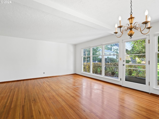 interior space featuring a chandelier, a textured ceiling, light hardwood / wood-style floors, and a healthy amount of sunlight