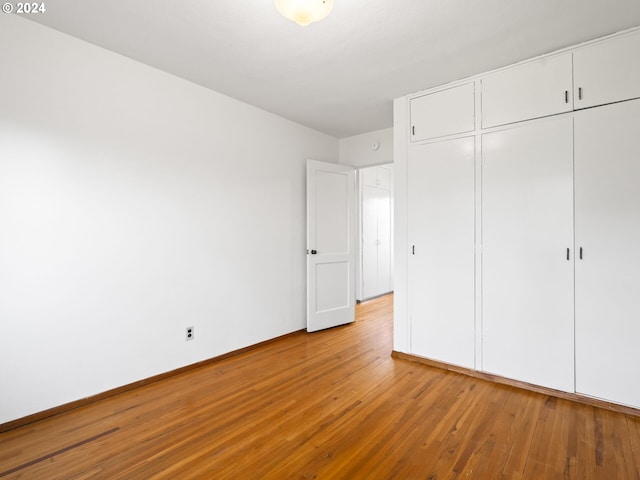 unfurnished bedroom featuring light hardwood / wood-style floors and a closet