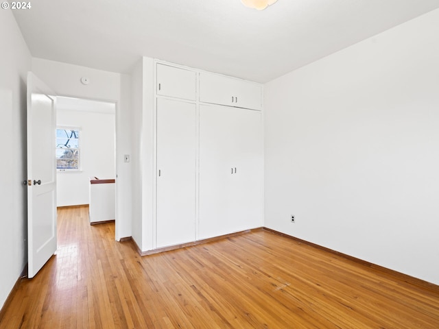 unfurnished bedroom featuring a closet and light wood-type flooring