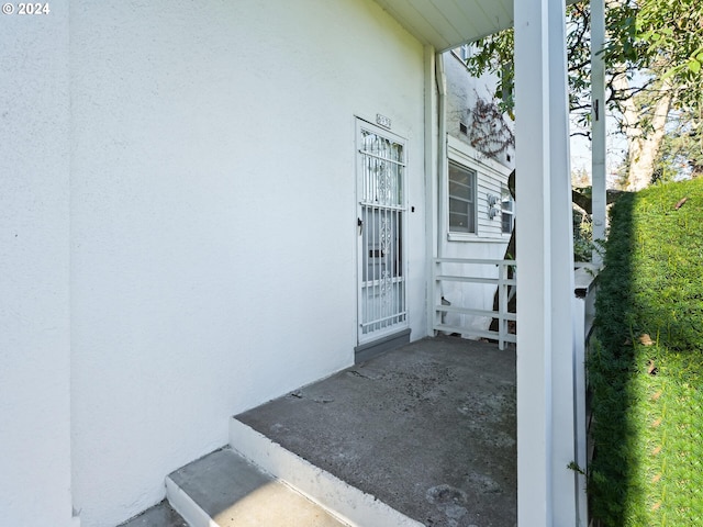 view of exterior entry featuring covered porch