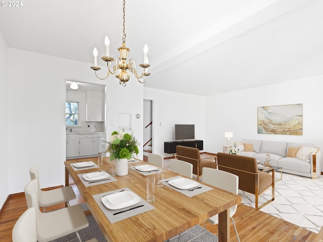 dining space with a notable chandelier, sink, and light hardwood / wood-style flooring