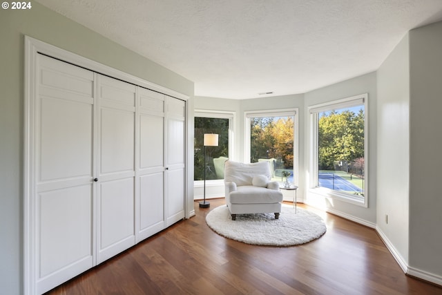 unfurnished room with dark wood-type flooring and a textured ceiling