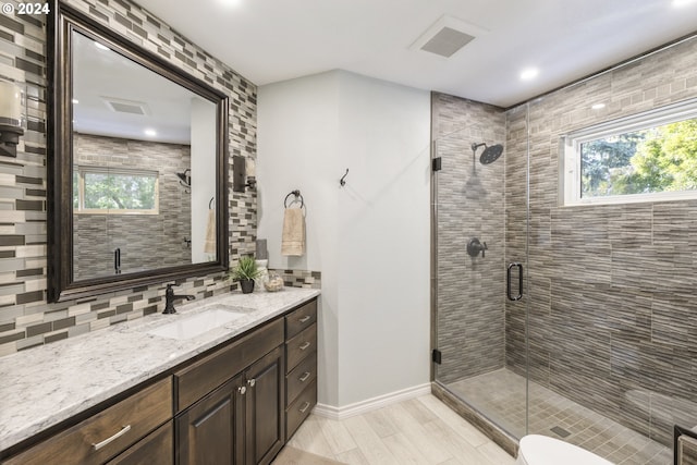 bathroom featuring vanity, hardwood / wood-style flooring, a healthy amount of sunlight, and an enclosed shower