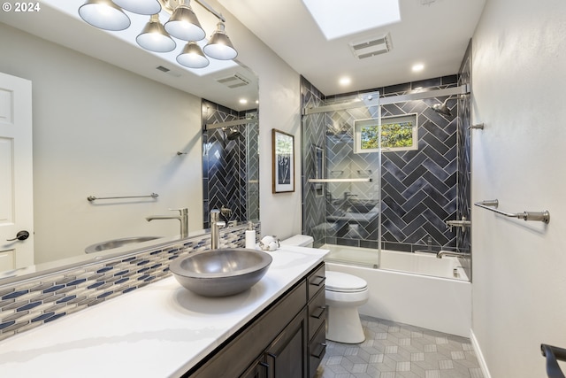 full bathroom featuring vanity, decorative backsplash, combined bath / shower with glass door, and toilet