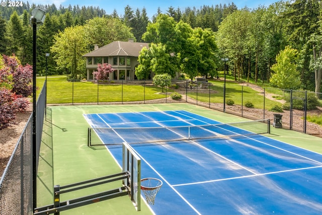 view of sport court with a lawn