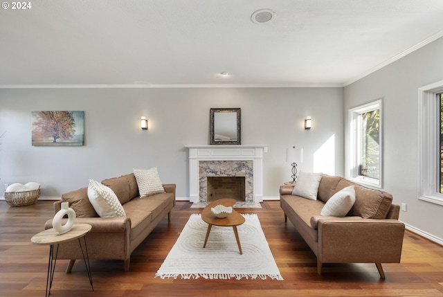 living room with crown molding, a high end fireplace, and wood-type flooring