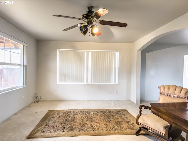 living area with ceiling fan and light colored carpet