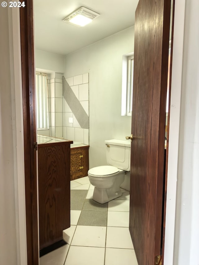 bathroom featuring tasteful backsplash, tile patterned flooring, vanity, and toilet