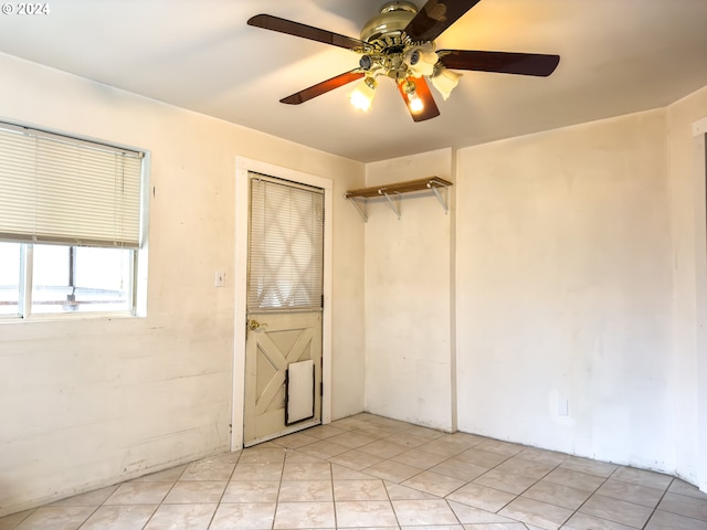 empty room featuring ceiling fan and light tile patterned flooring