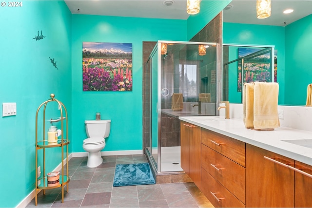 bathroom featuring toilet, a shower with door, and vanity