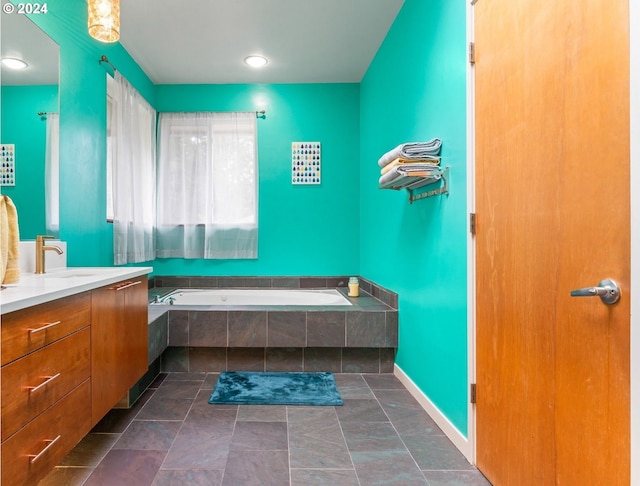 bathroom featuring tiled bath and vanity