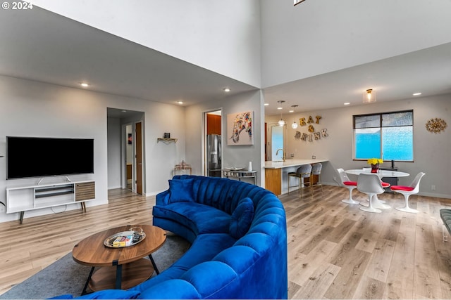 living room with light wood-type flooring and sink