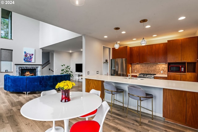 dining space with a fireplace, sink, and hardwood / wood-style floors