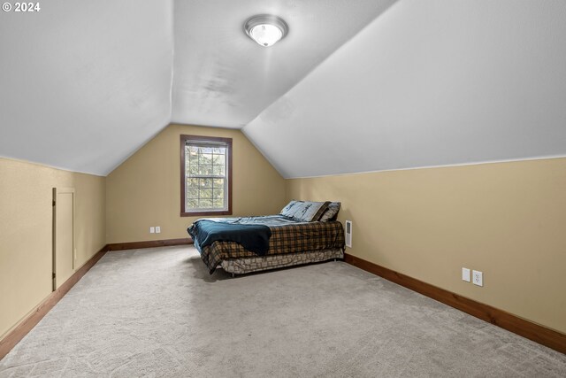 additional living space with vaulted ceiling and carpet flooring