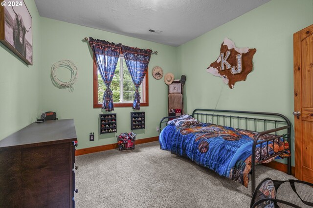 carpeted bedroom with a textured ceiling and a closet