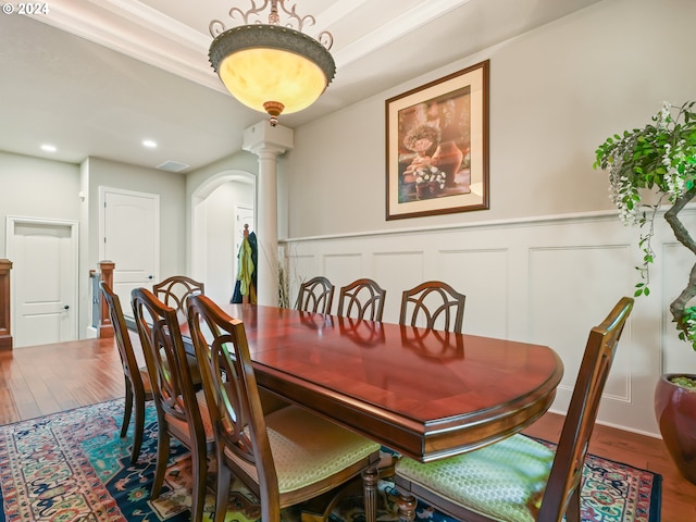 dining area with wood-type flooring and decorative columns