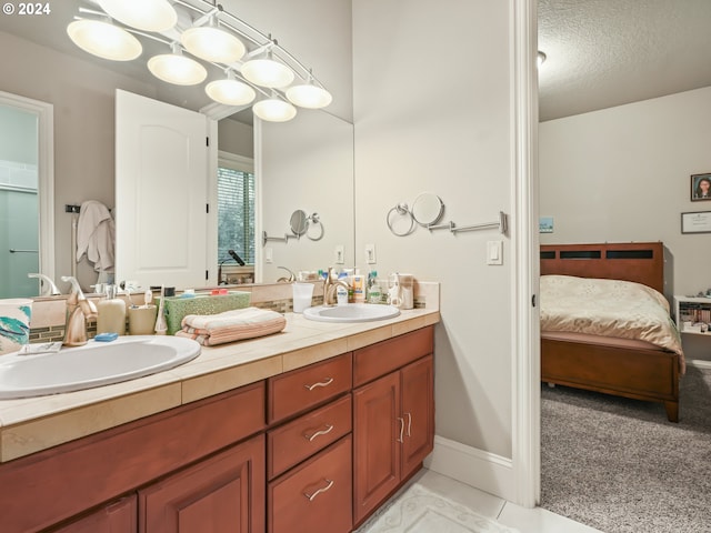 bathroom with tile patterned flooring, vanity, and a textured ceiling