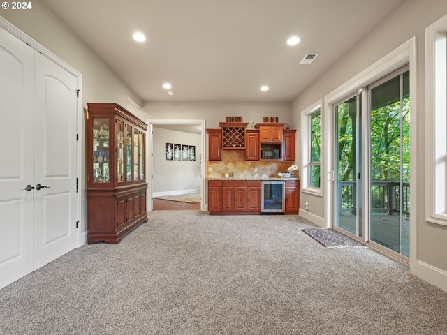 kitchen with light carpet, beverage cooler, and backsplash