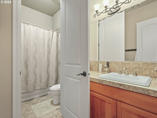 full bathroom with vanity, tasteful backsplash, a textured ceiling, shower / tub combo, and toilet