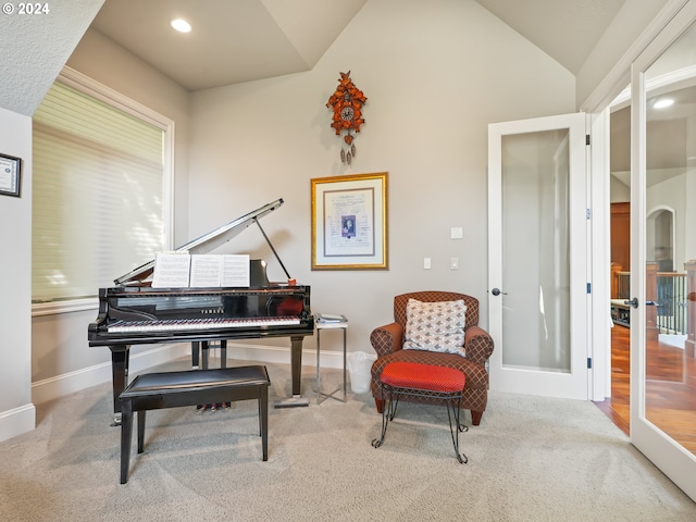 living area featuring lofted ceiling, french doors, and light colored carpet