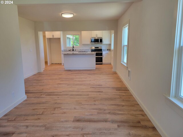80 S 21st St, Saint Helens, OR 97051 - kitchen with stainless steel appliances, white cabinetry, a sink, baseboards, and light wood-type flooring