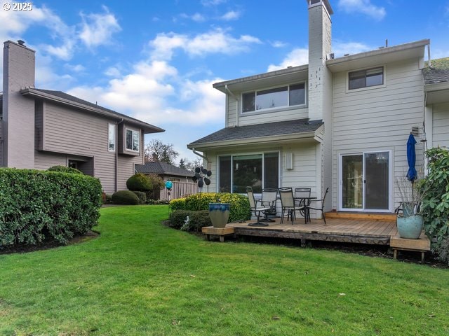 back of property featuring a deck and a lawn