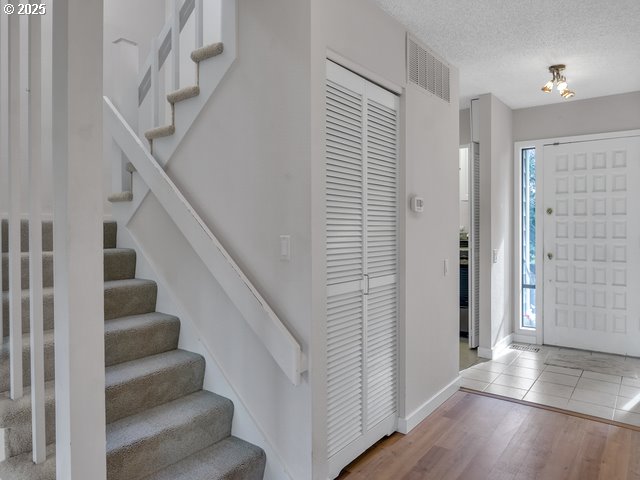 foyer entrance featuring hardwood / wood-style flooring and a textured ceiling