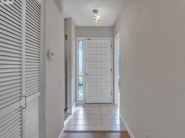 tiled entryway featuring a textured ceiling