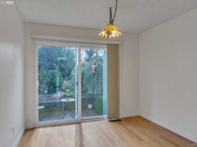 empty room with hardwood / wood-style flooring and a textured ceiling