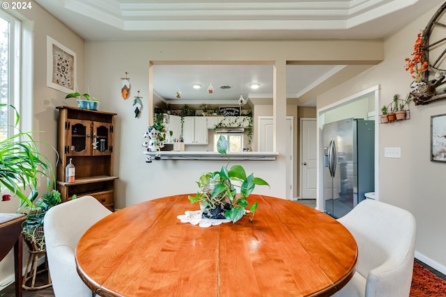 dining space featuring a tray ceiling and ornamental molding