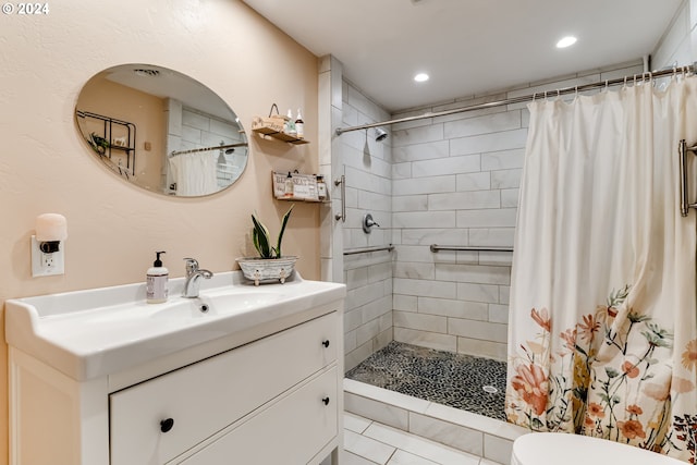 bathroom featuring tile patterned flooring, vanity, toilet, and walk in shower