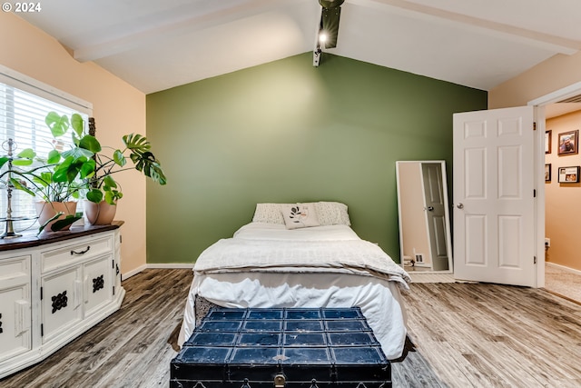 bedroom with hardwood / wood-style floors and vaulted ceiling with beams