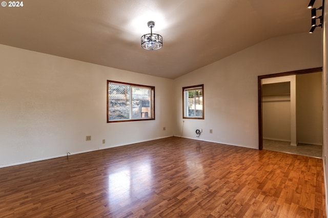 unfurnished bedroom featuring vaulted ceiling and wood-type flooring